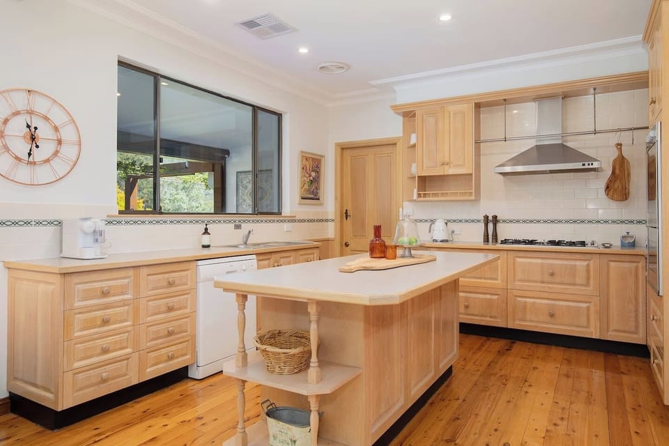 Whip up hearty meals or laid-back platters in the charming country-style kitchen, complete with an oven, dishwasher, and island bench for prepping and gathering.