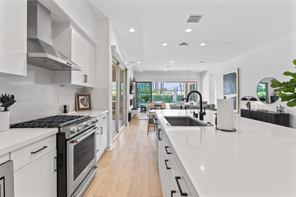 Open-concept kitchen with sleek island and garden view.