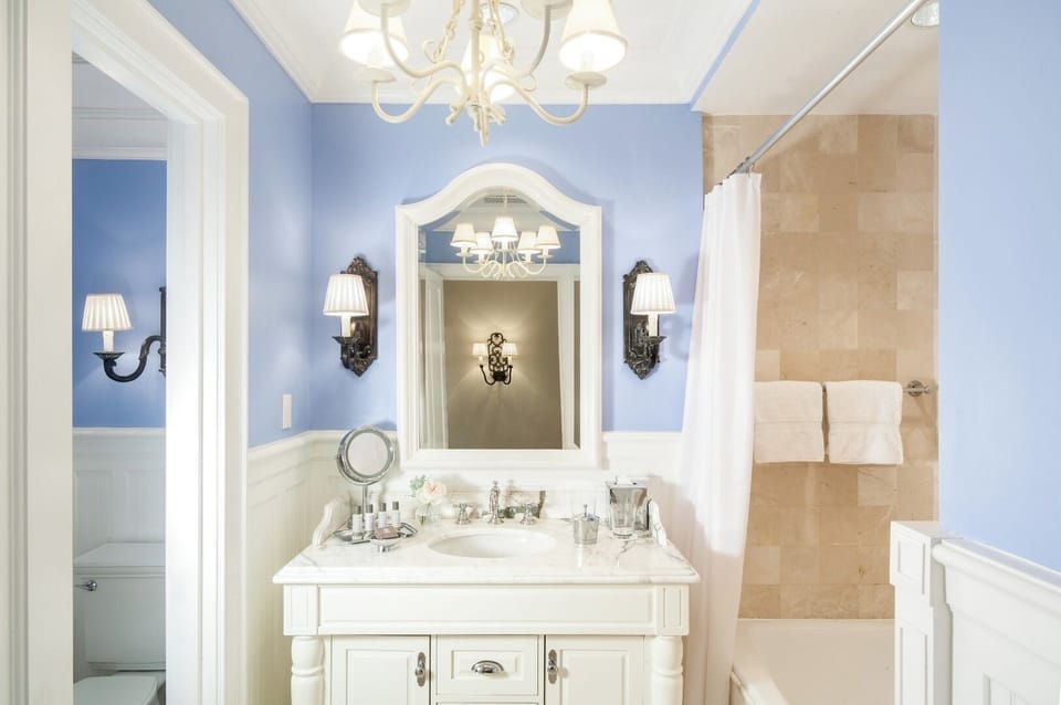 Refresh under warm lights in a spa-inspired marble bath.