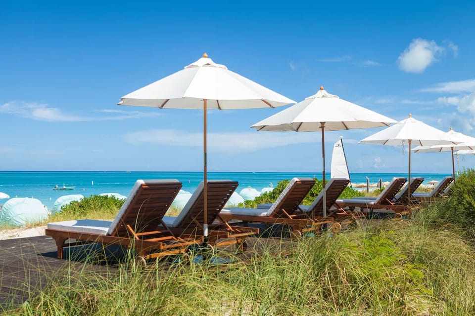 Lounge oceanside under crisp umbrellas with sea breezes.