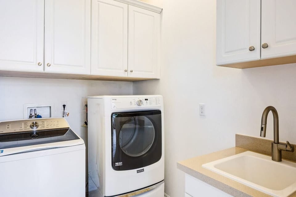 Full-size washer and dryer with upper cabinets.