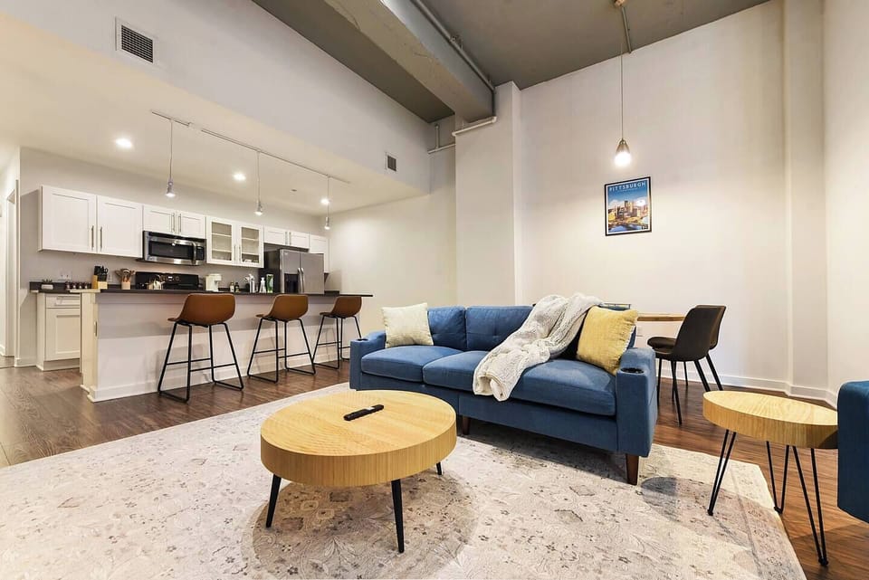 Relax in a spacious living area featuring a cozy sofa and plenty of natural light.