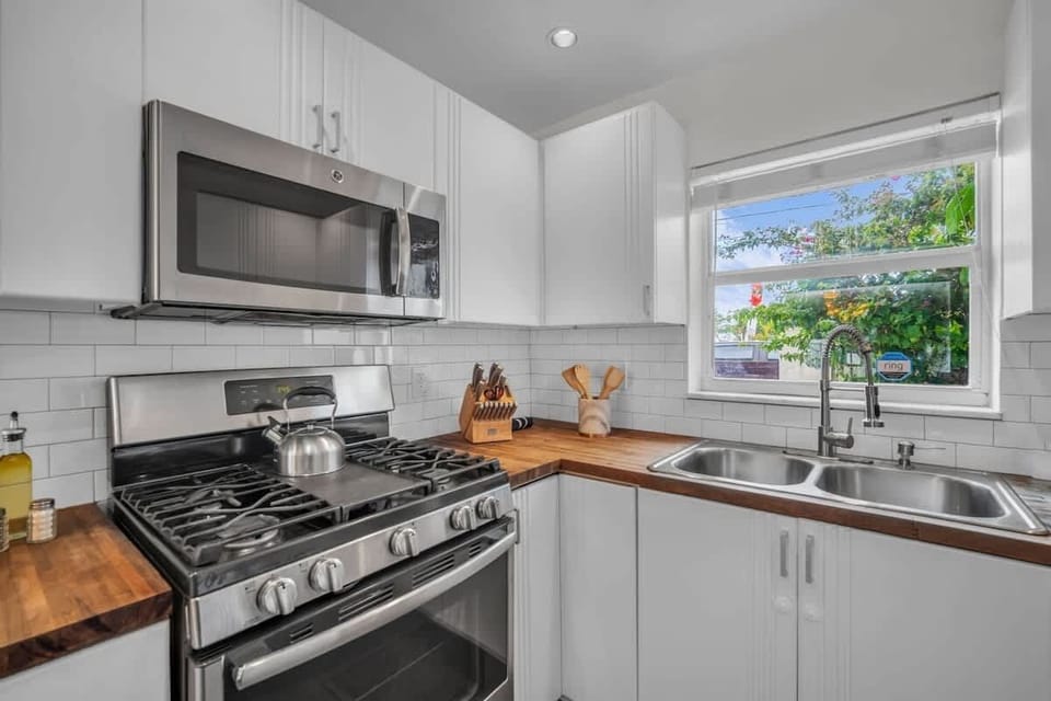 Whip up meals in this bright, modern kitchen—complete with stainless steel appliances, butcher block countertops, and a sunny window view. A cozy, homey space that makes dining in a delight!