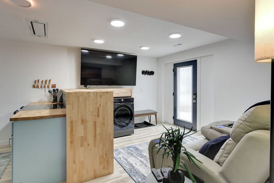 Relax in your modern basement retreat with plush seating, entertainment center, and convenient laundry facilities.