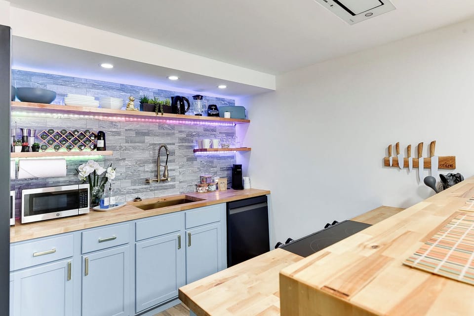 Cook memorable meals in your stylish kitchen with butcher block counters, modern appliances, and atmospheric LED lighting.