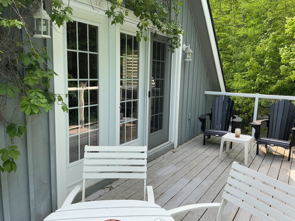 Balcony with Muskoka chairs and dining area, off bedroom.