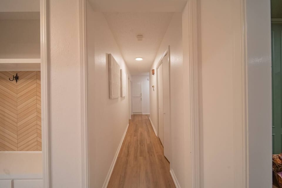 Clean bright hallway with modern flooring leading to the cozy bedrooms.