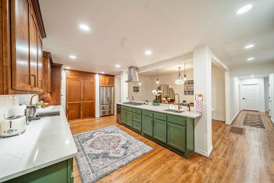 This beautifully renovated kitchen features modern lighting, elegant finishes, and an open layout perfect for hosting and entertaining—ideal for families and groups in Oklahoma City.