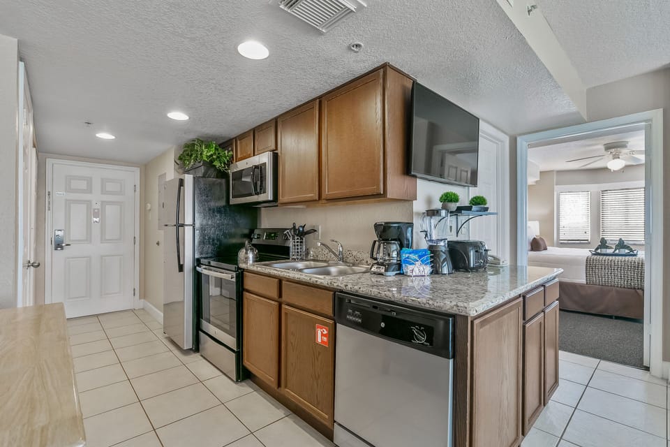 The modern kitchen is equipped with stainless steel appliances, granite countertops, and essential kitchenware, making meal preparation enjoyable and effortless.