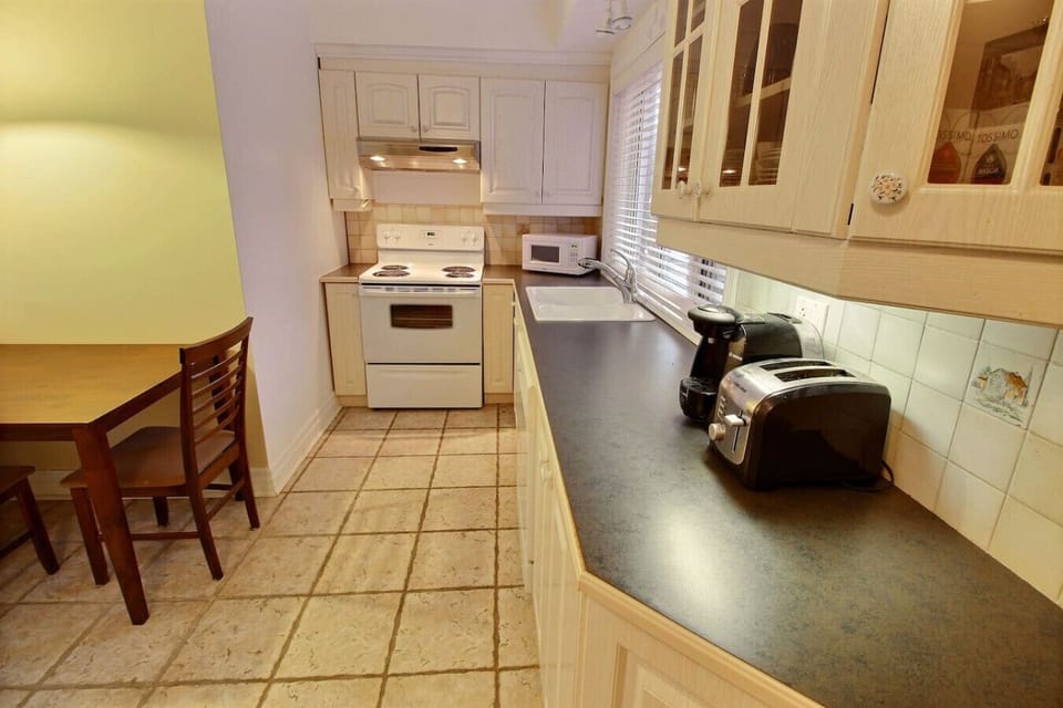 Dining Nook in Montréal Apt: Enjoy meals or work comfortably at this dedicated table. Full kitchen and coffee maker nearby.