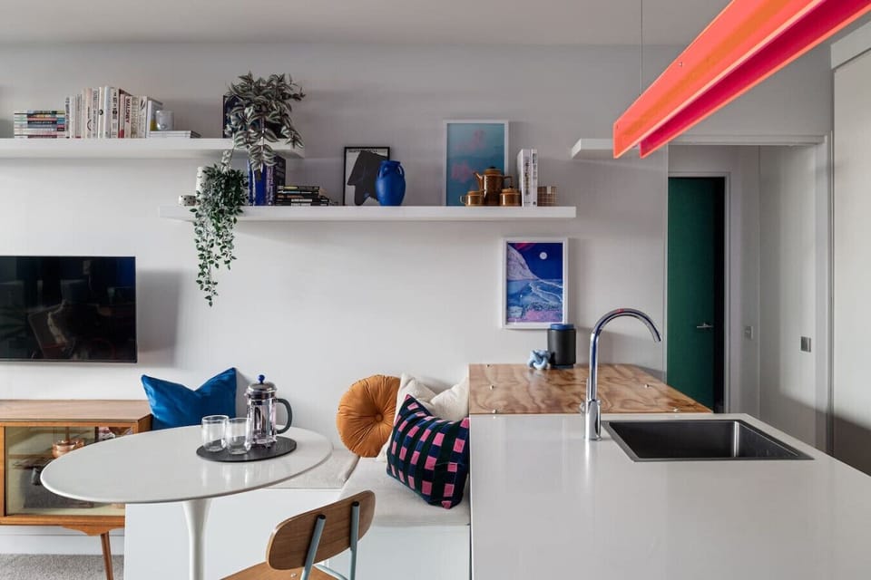 Make yourself at home in this colorful, thoughtfully styled space featuring a stylish breakfast nook, modern kitchen, and unique decor that adds charm and character throughout