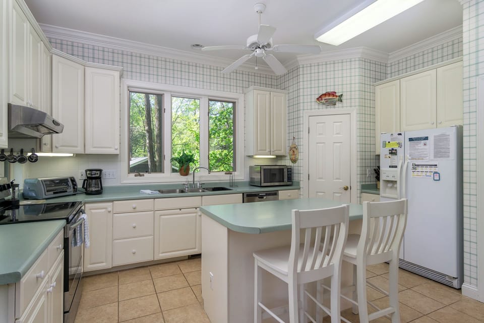 Kitchen with drip-style coffee pot, breakfast nook for 6, and island seating for 2