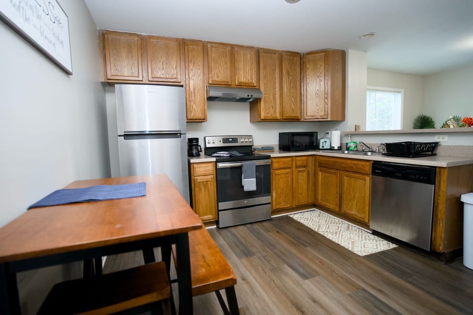 Fully equipped kitchen with stainless steel appliances, wooden cabinetry
