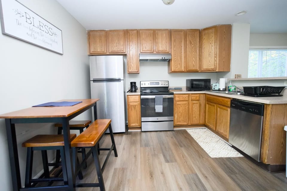 Fully equipped kitchen with stainless steel appliances, wooden cabinetry.