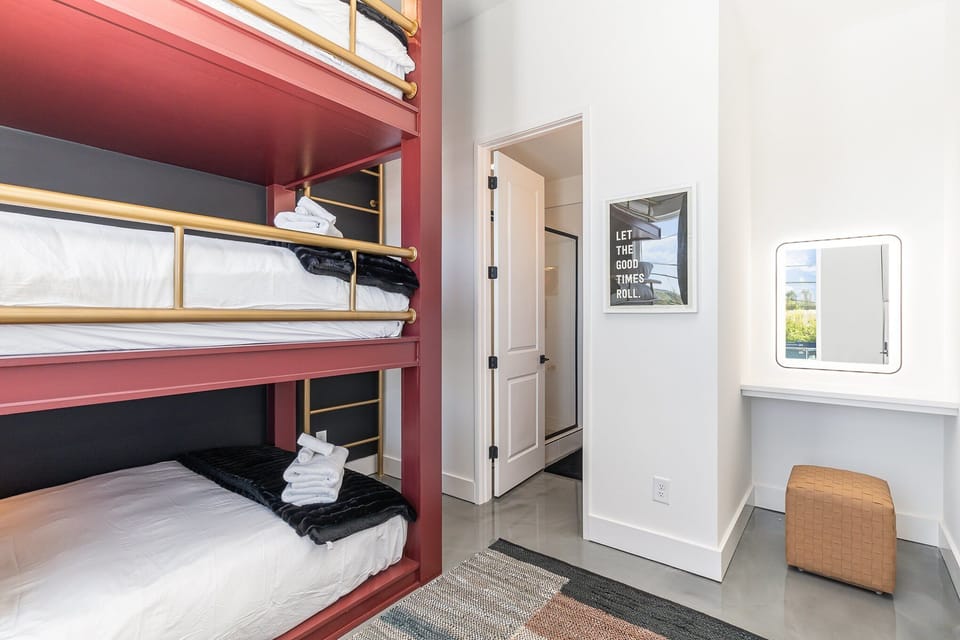 1st Floor: 4th Bedroom with a custom triple Full Bunk-Bed, Smart TV, LED Vanity w/ stool, and an en-suite bathroom.