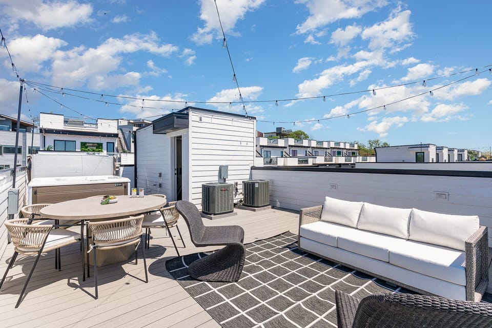 Rooftop deck with a hot tub, outdoor dining for 6, and cozy lounge seating—perfect for unwinding.