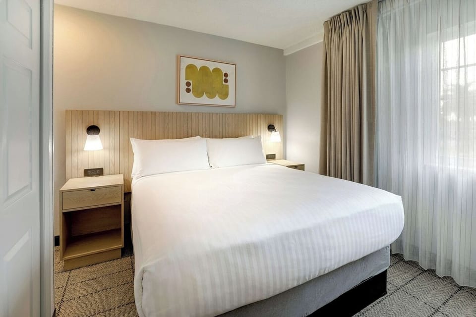 Sink into fresh linens and a neatly styled, modern headboard.