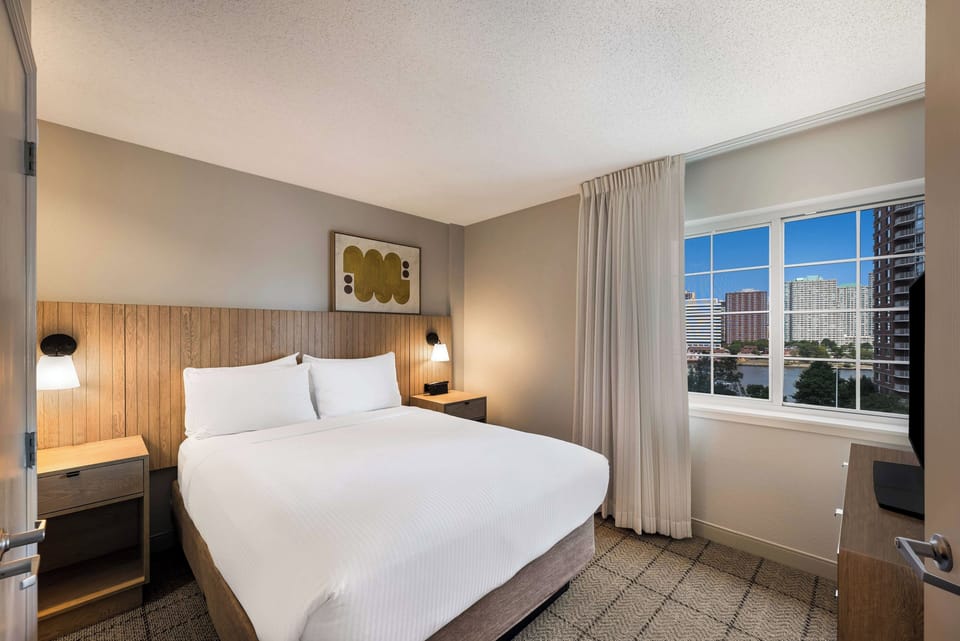 Drift off comfortably with warm lighting and sweeping city windows.