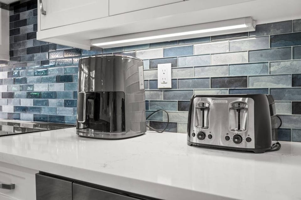 Kitchen: Modern appliances and a stylish blue backsplash invite culinary adventures!