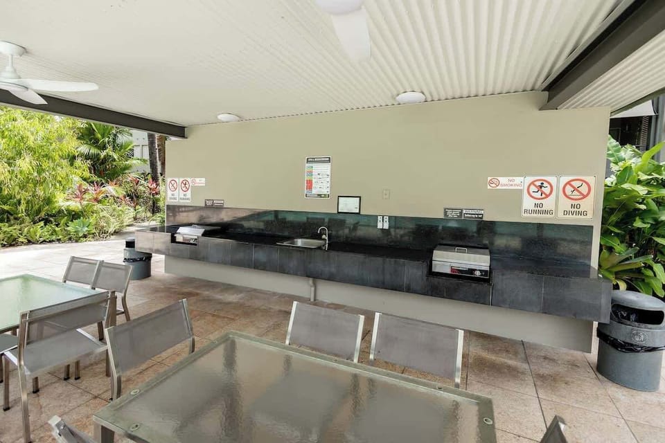 Outdoor shared BBQ and outdoor dining area overlooking the pool