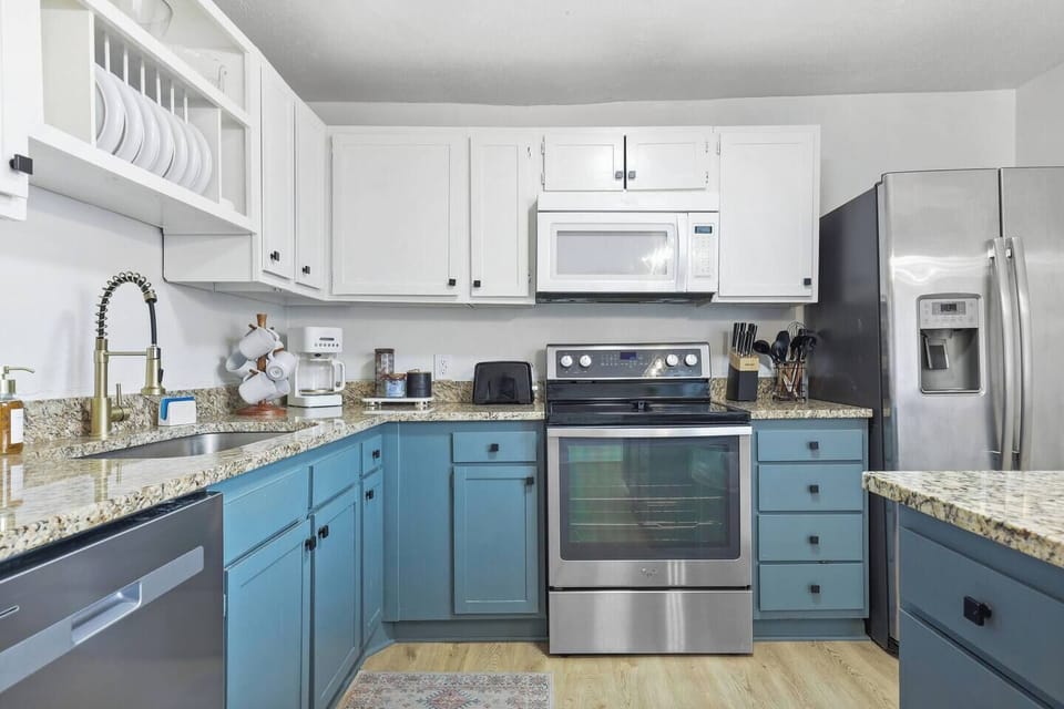 Kitchen features a full size range with glass cooktop, over range microwave, new dishwasher and side by side fridge.