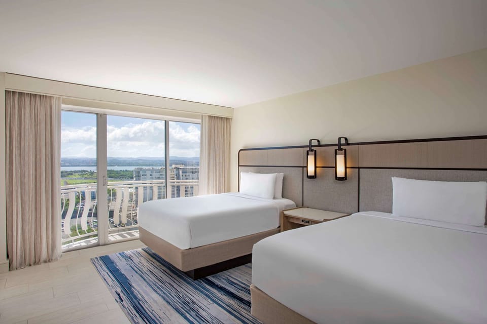 Wake up to sunlight and balcony views from crisp beds.
