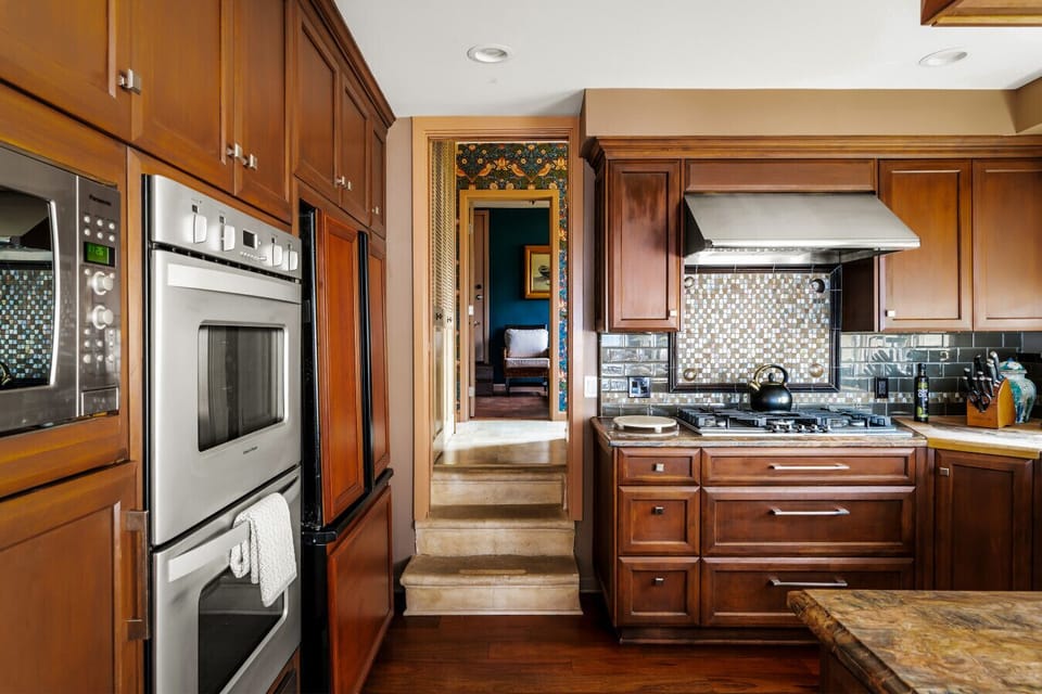 Timeless Elegance in Every Detail – Warm wood cabinetry and modern appliances blend seamlessly in this classic kitchen.