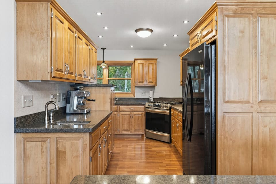 Kitchen features two sinks, one bar sink and a kitchen sink by the window. 