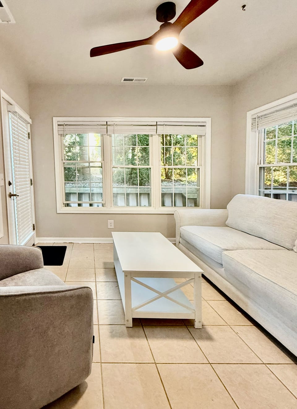 Finished sunroom with HVAC, couch and chair as well as private entrance.