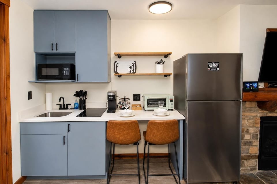 Newly remodeled studio kitchen features a full-size fridge, quartz counters, microwave, air fryer/toaster oven, and 2-burner induction cooktop.