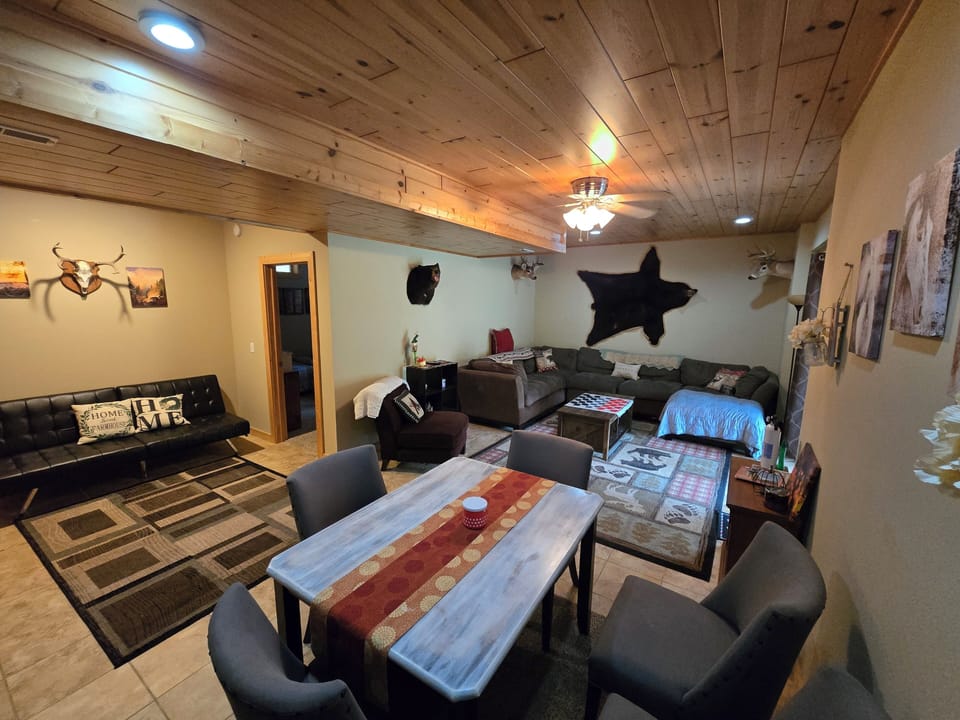 Large downstairs living room with big couch, dining table and futon.