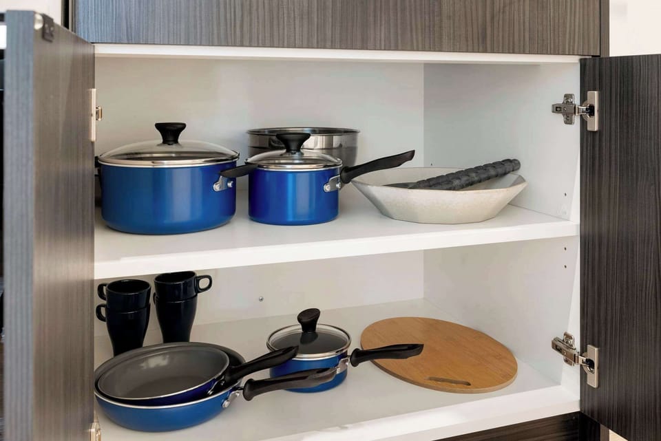 Well-stocked cookware shelf makes home cooking simple and stress-free.