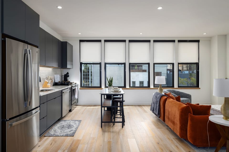 Relax and unwind—this inviting living room is designed for comfort, with vibrant decor, cozy seating, and a large TV for all your entertainment needs.