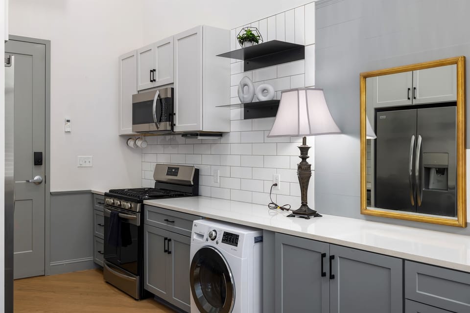 Fully equipped kitchen featuring a sleek design with amenities like a dishwasher and Keurig for your convenience. Even a combo washer dryer!