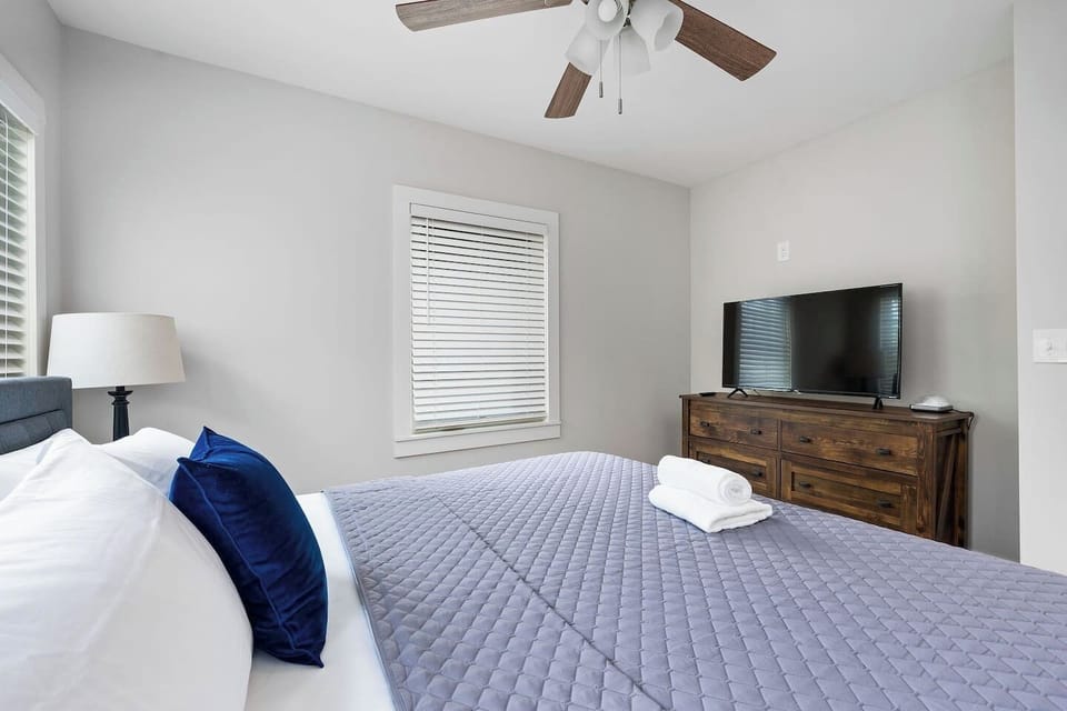 This inviting bedroom features a luxurious king-sized bed, tastefully decorated to provide a serene and spacious retreat for guests.