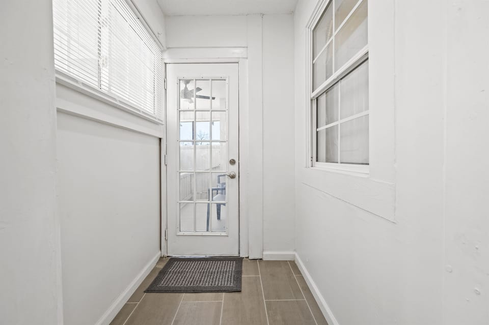 Bright kitchen hallway leading to a screened-in back patio, perfect for relaxation.