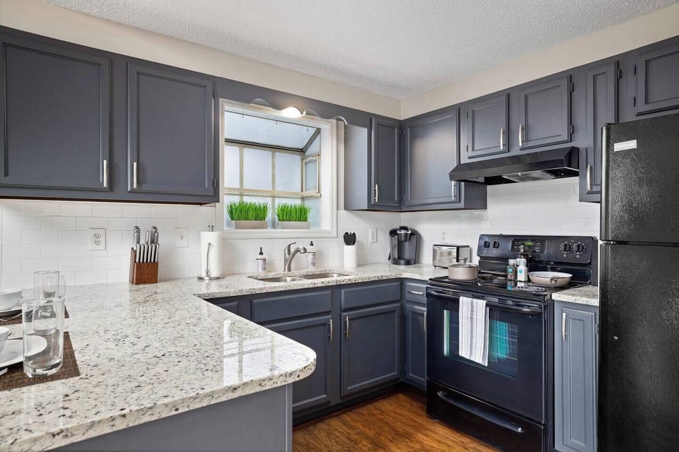 Bright and functional kitchen sink area with granite counters and a window view.