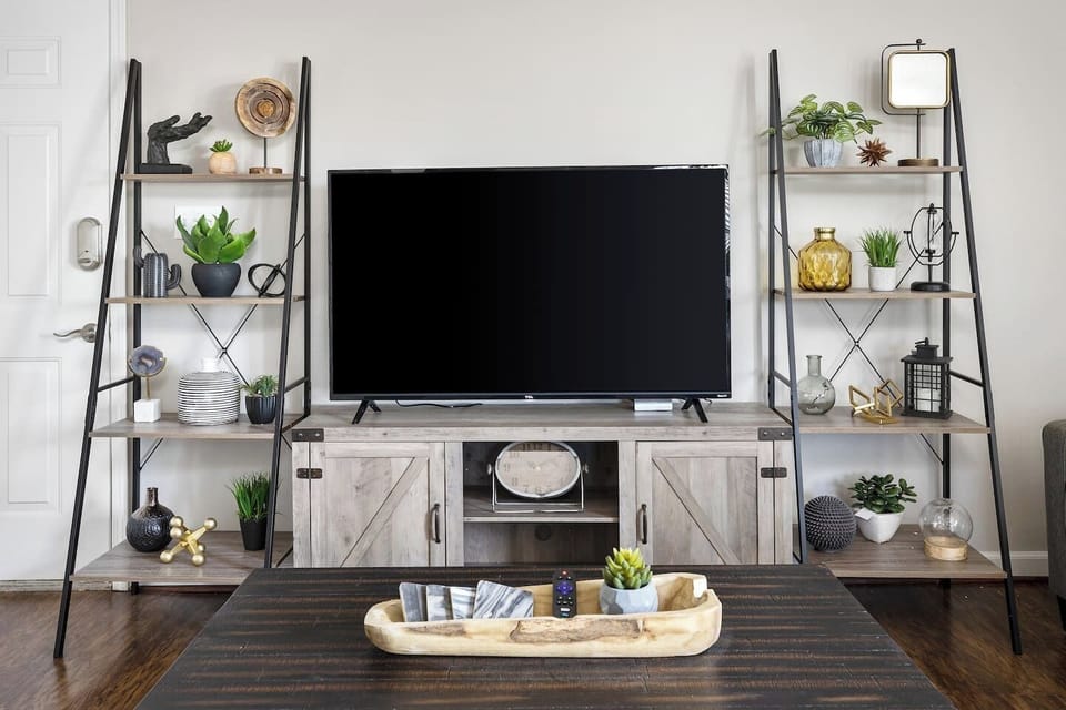 Entertainment area featuring a large flat-screen TV surrounded by chic shelving and decor accents.