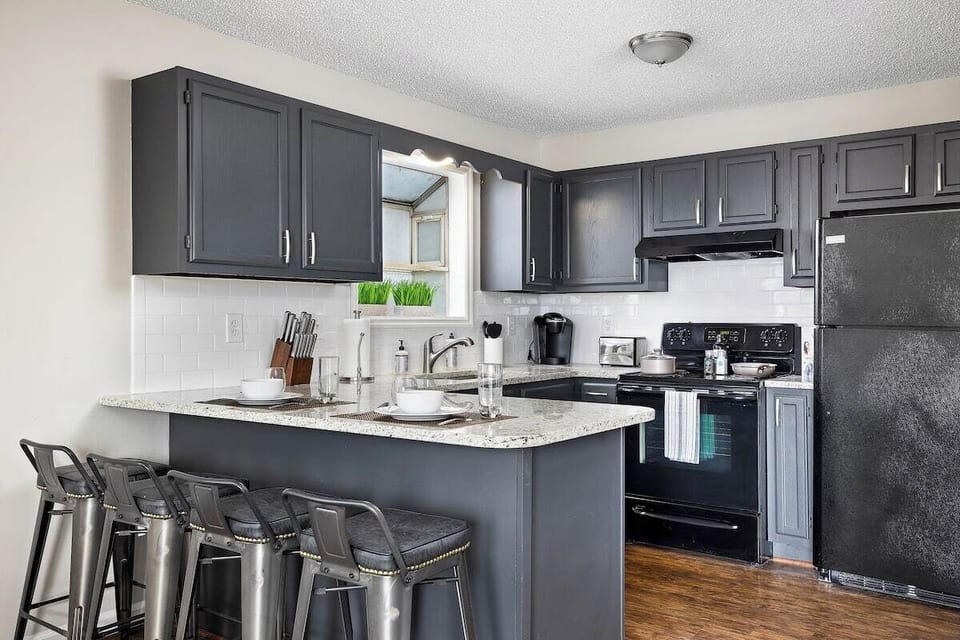Fully equipped kitchen with modern appliances, ample counter space, and bar seating for convenience.