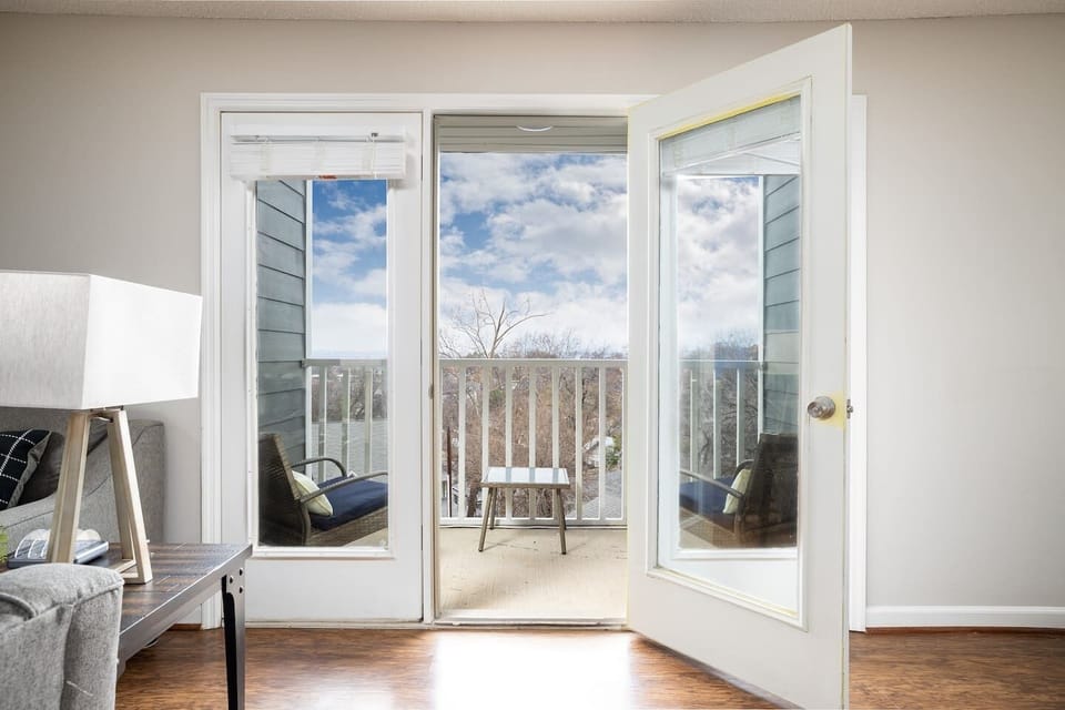 Bright and airy view from the living room leading to a balcony with stunning outdoor scenery.
