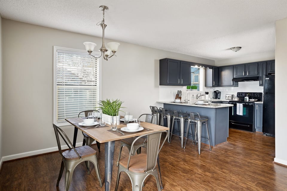 Open dining area leading into a sleek, modern kitchen with breakfast bar