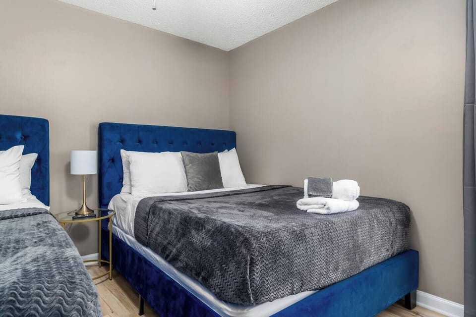 Bedroom with blue upholstered beds, cozy gray bedding, and modern decor for a serene retreat.