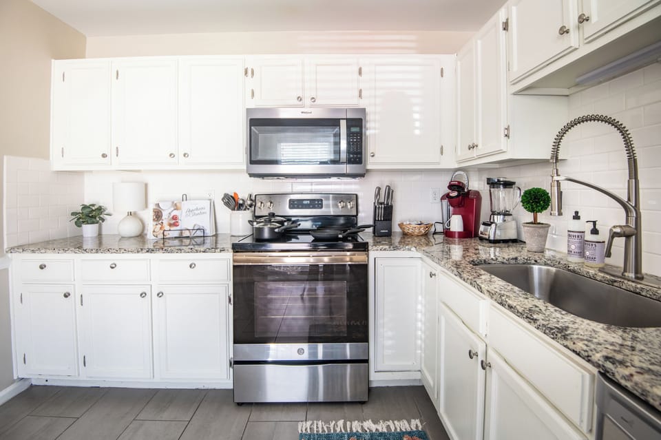 Bright and functional kitchen with white cabinetry, stainless steel appliances, and plenty of workspace.