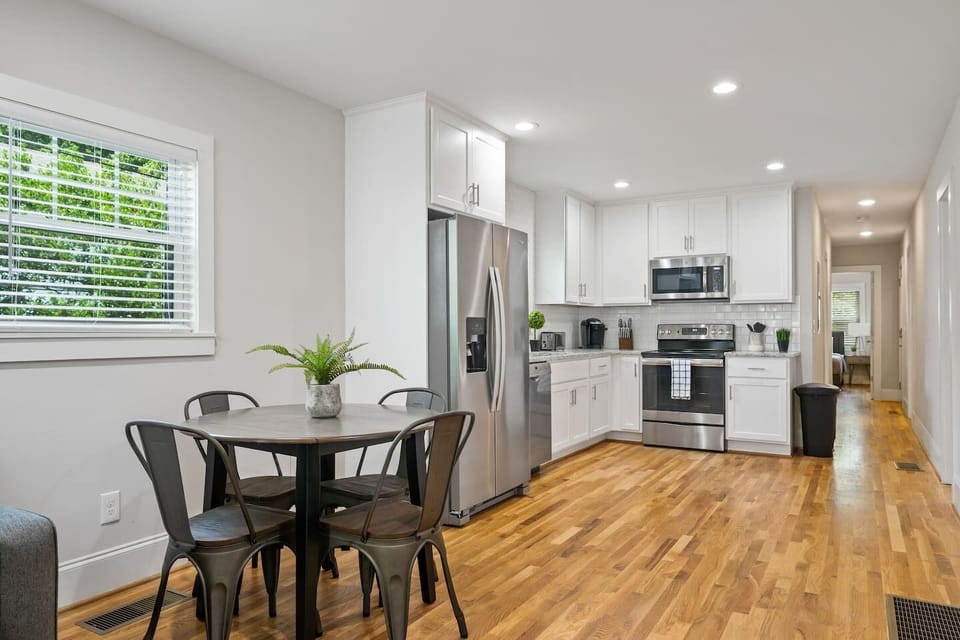 This view highlights the kitchen's expansive countertops and the adjacent dining area, emphasizing space and functionality.
