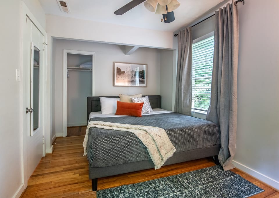 pacious bedroom with a king bed, ceiling fan, and access to a private workspace.