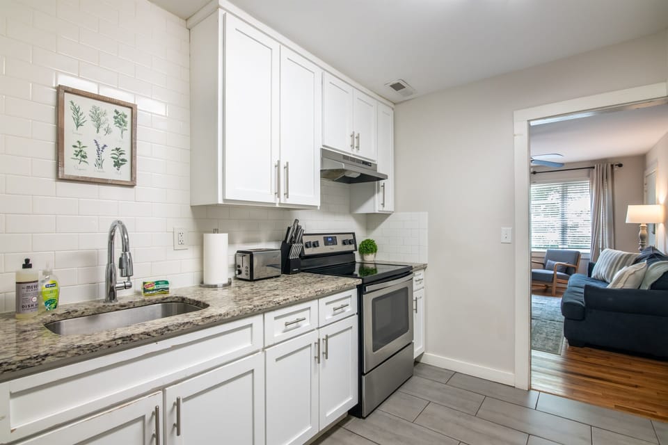 Modern kitchen with stainless steel appliances, white cabinetry, and granite countertops. Fully equipped for preparing your favorite meals.