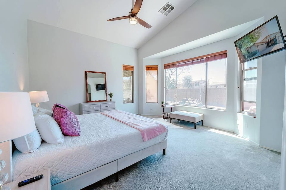 Sunny suite with king bed, bay window seat, TV, and vaulted ceiling