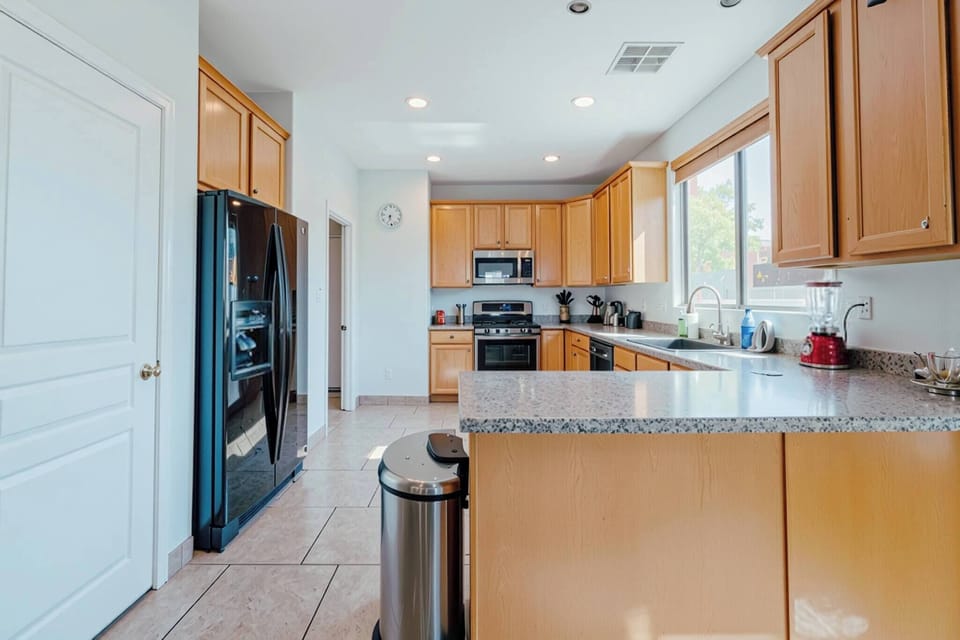 Bright, fully equipped kitchen with granite, gas range, and big windows