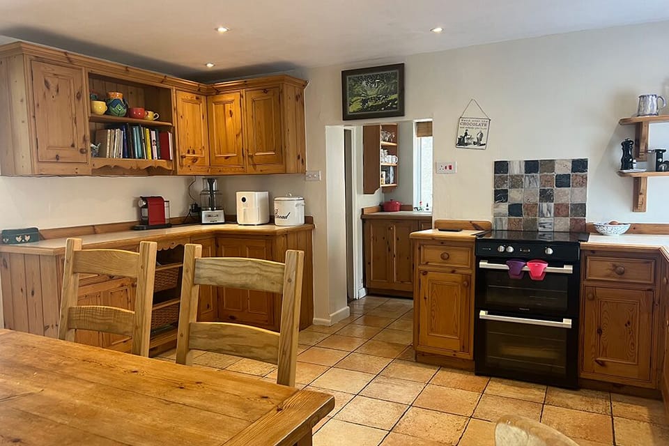 Looking through into the scullery space with sink and washing machine, fridge...