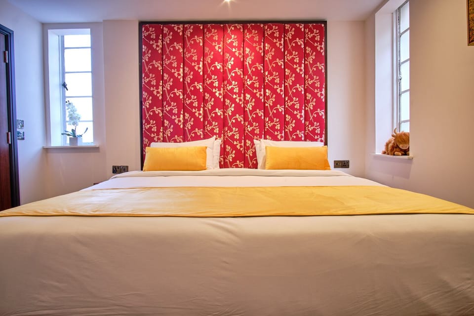 Recharge in a grand king bed framed by dramatic designer wallpaper.